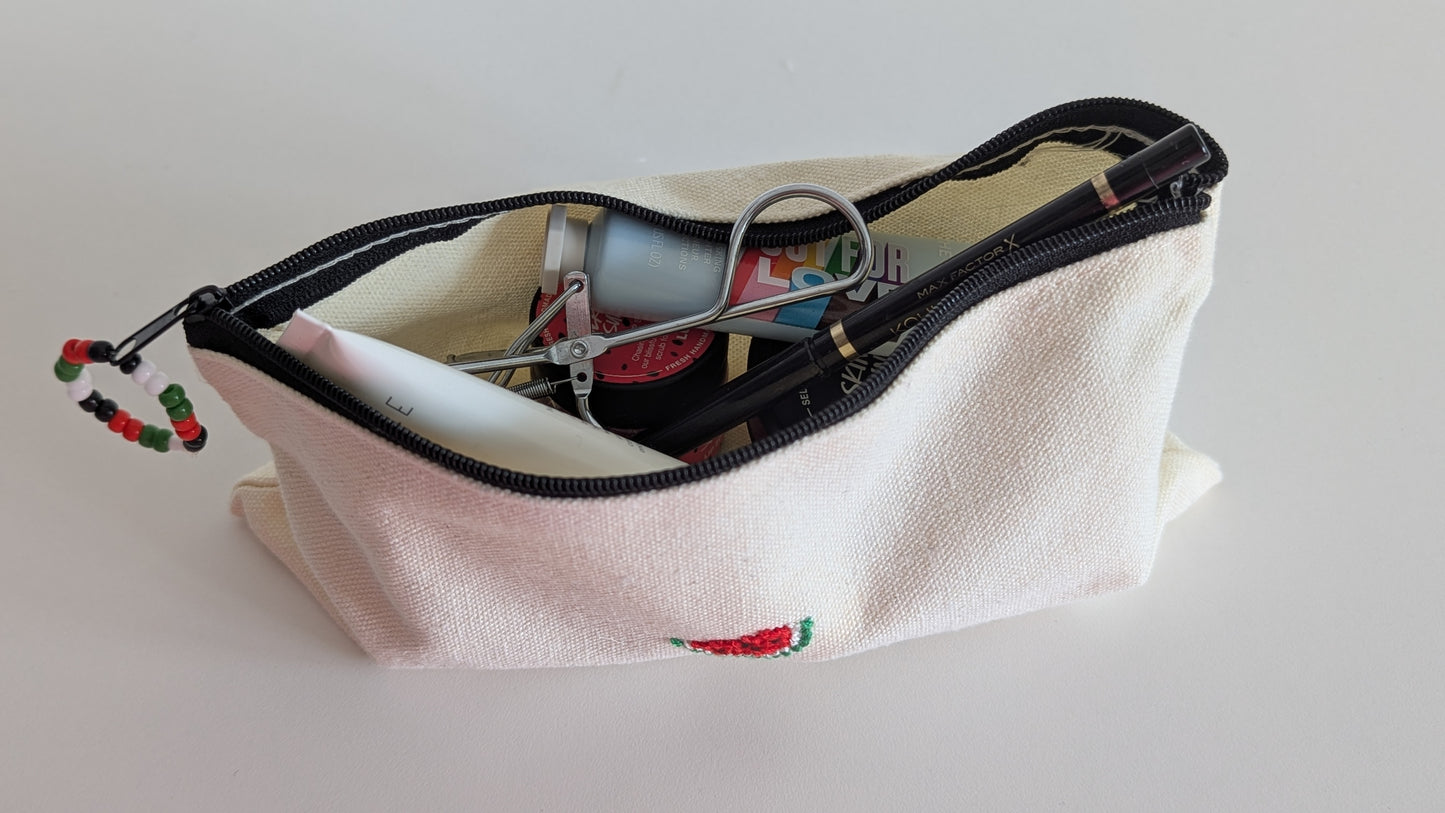 Cotton pouch with watermelon embroidery full of makeup