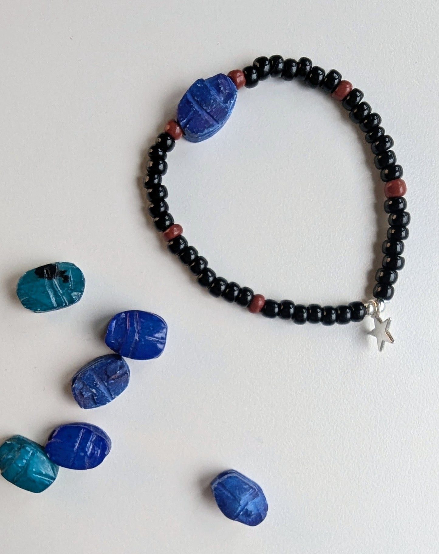 scarab bracelet with black and brown beads with more scarab stones on the side