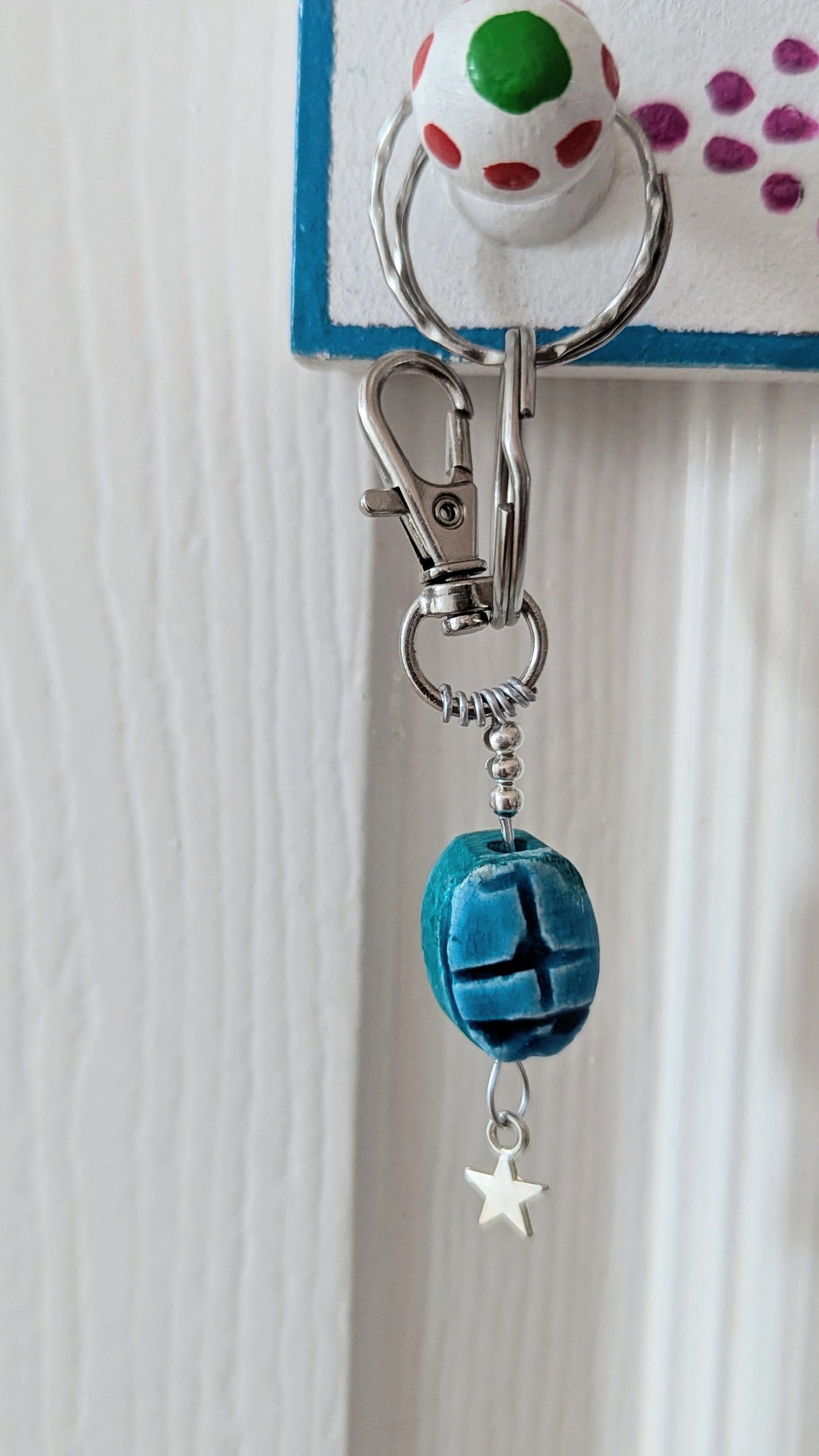 blue scarab on a silver wire keyring with sterling silver star, hanging 