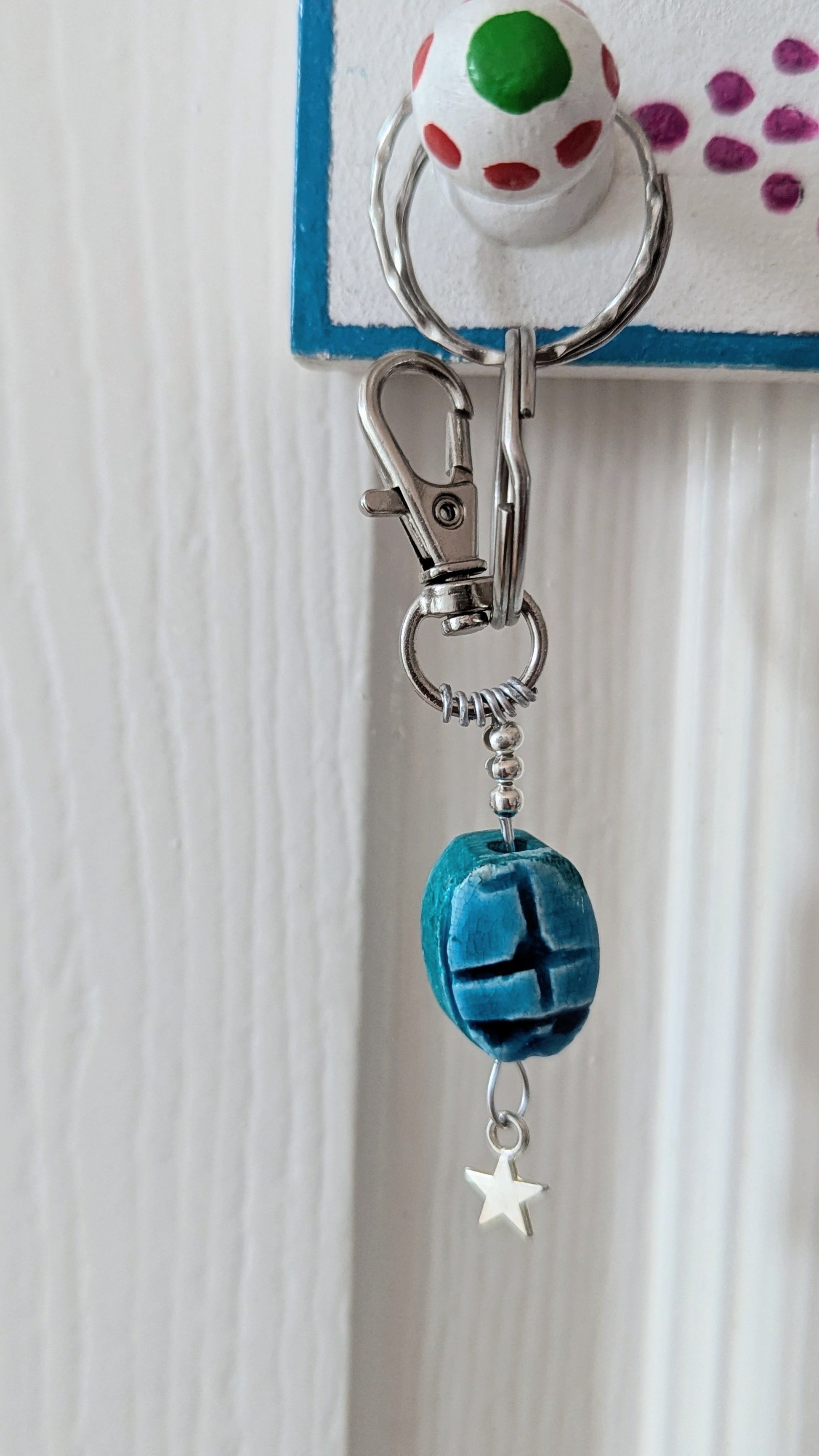 blue scarab on a silver wire keyring with sterling silver star, hanging 