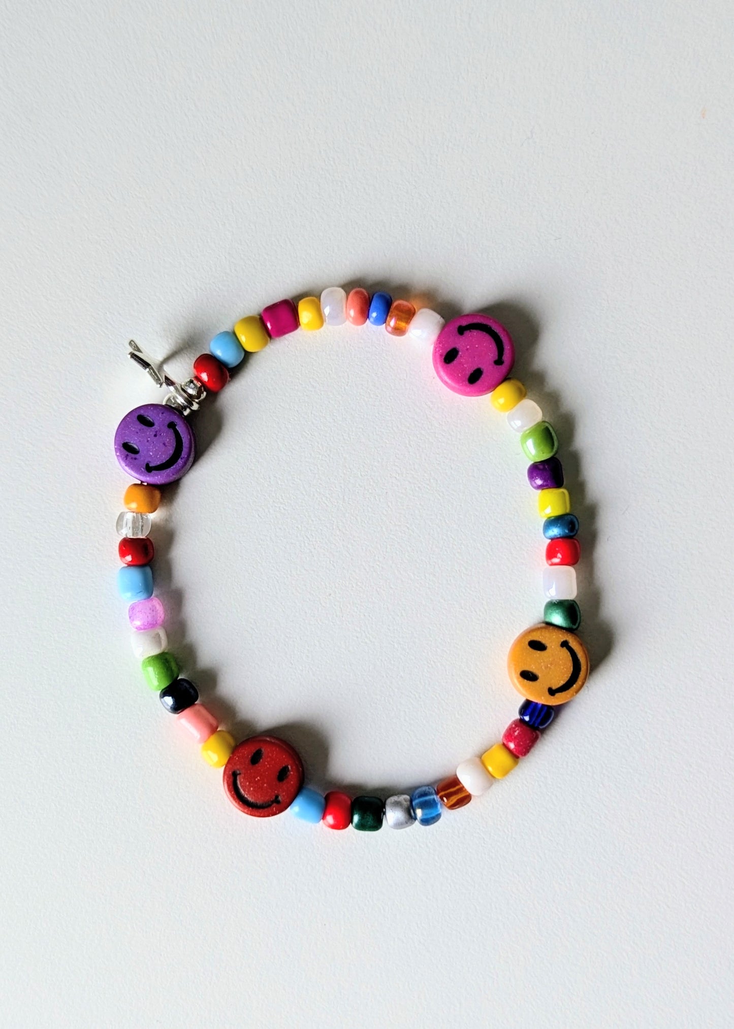colourful glass beads bracelet with smiley face beads against a white background