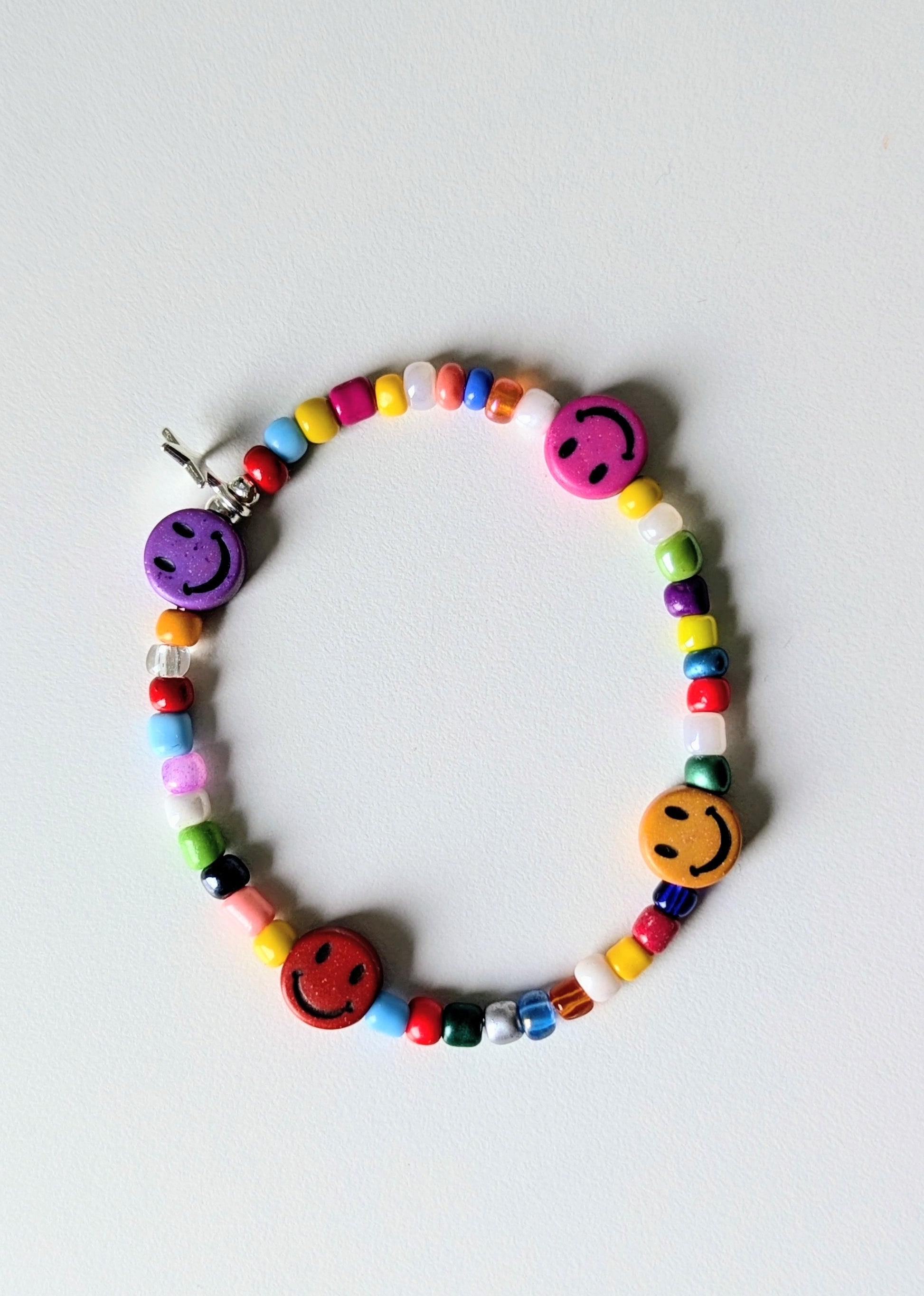 colourful glass beads bracelet with smiley face beads against a white background